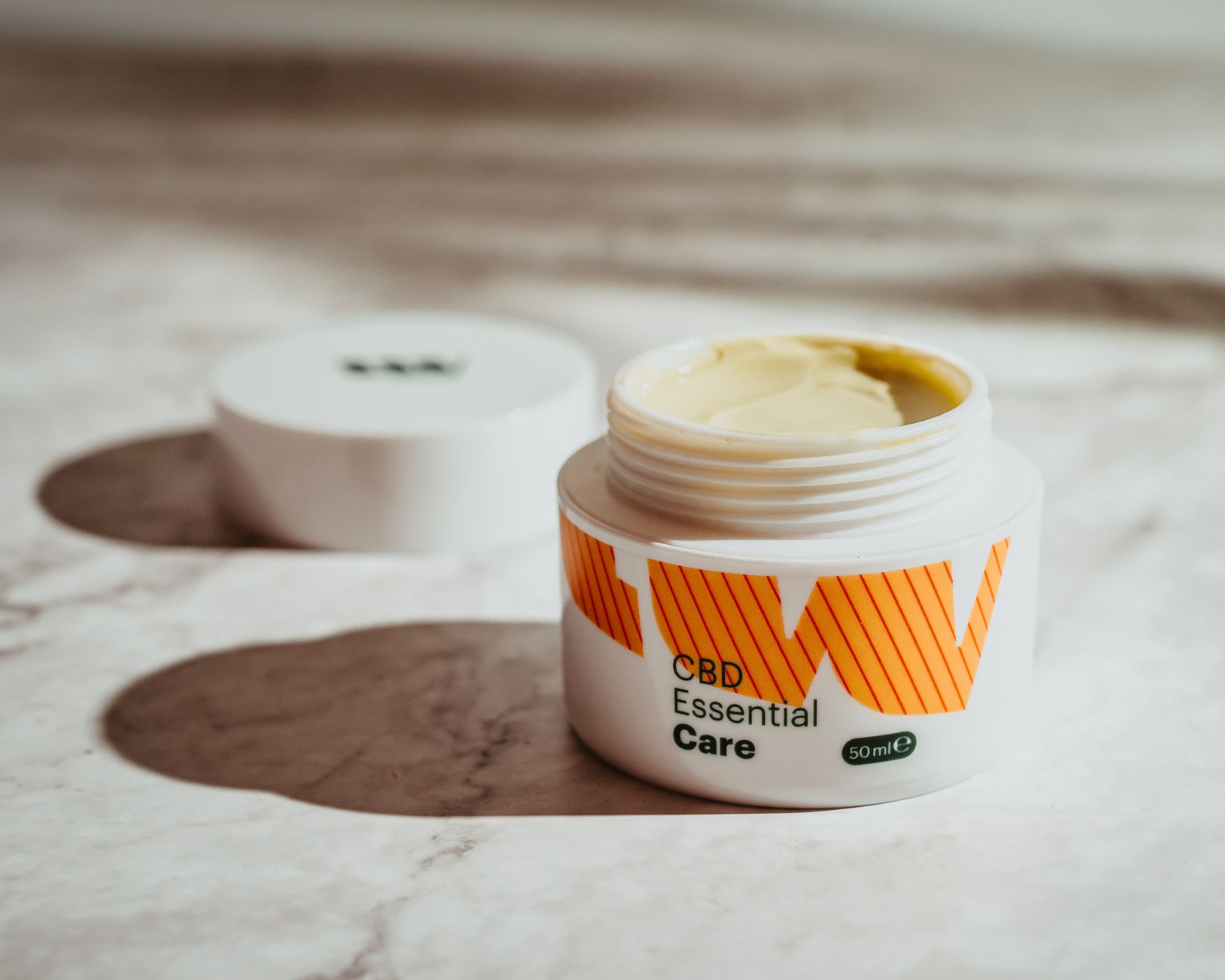 CBD Essential Care Tiegel offen mit Creme auf Marmor